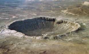 An aerial view of the Barringer Crater, also known as Meteor Crater, located in Arizona, USA. The large circular depression is approximately 1,200 meters in diameter and 170 meters deep, formed by the impact of a meteorite around 50,000 years ago