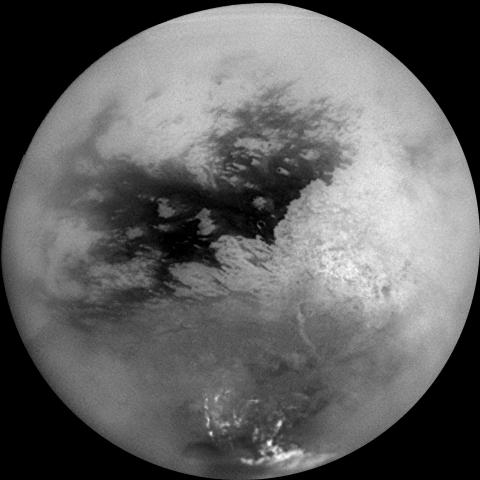 Grayscale image of Titan, Saturn's largest moon, showing dark and light regions on its hazy surface