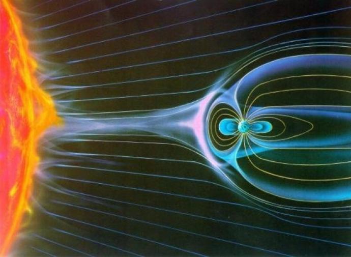 Illustration showing part of the sun on the left and a small earth on the right against a black background. Horizontal lines in shades of pink and blue are shown across the image. Around the earth there are lines flowing out of it that form an oval on the left side and a stretched out oval on the right. There is a pink, fiery area on the Sun-side of the planet.