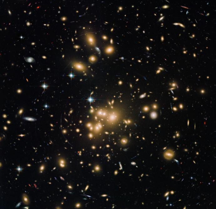 Numerous galaxies across a black background. Most of them give off a yellow or orange glow, but some are whiter and bluer. Many look like smudged spheres, while others look like smuggled lines. They have a range of sizes. Though they're everywhere, most are found towards the centre of the image.